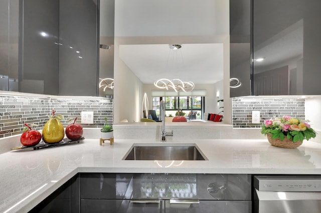 kitchen featuring stainless steel dishwasher, light stone countertops, sink, and decorative backsplash