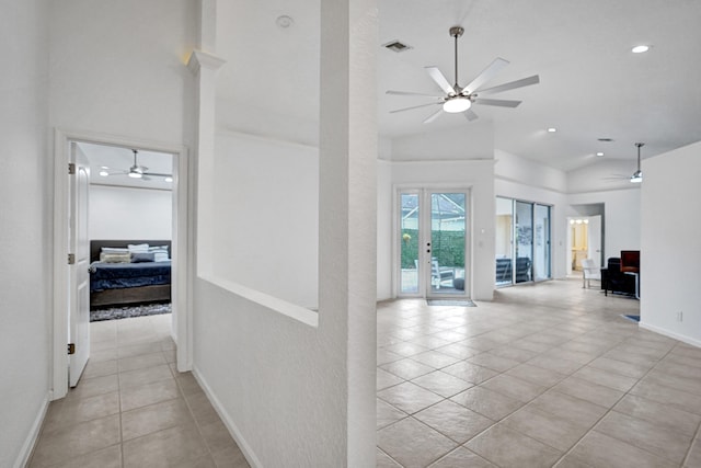 hallway with vaulted ceiling and light tile patterned flooring