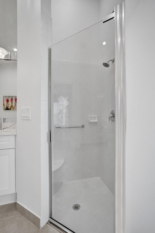 bathroom with tile patterned flooring, vanity, and a shower with door