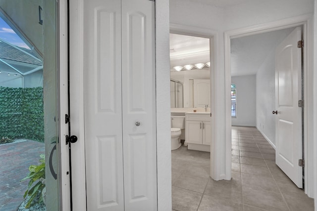 bathroom with tile patterned flooring, vanity, a healthy amount of sunlight, and toilet