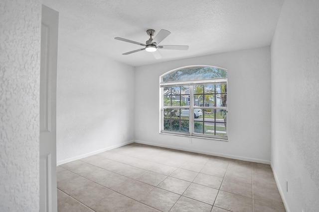 tiled spare room featuring a textured ceiling and ceiling fan