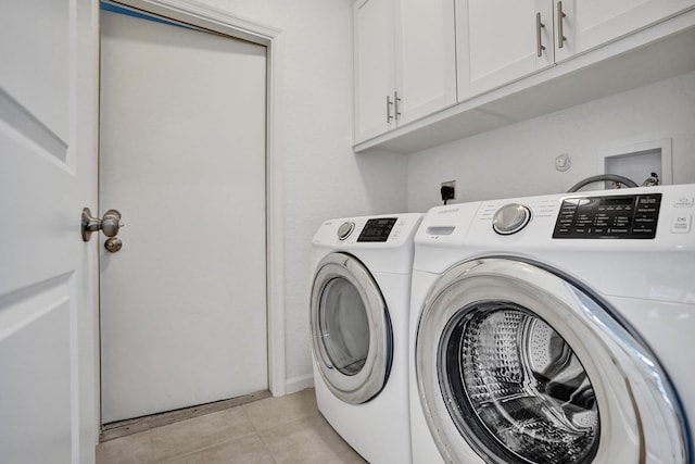 laundry room with cabinets, washing machine and clothes dryer, and light tile patterned flooring