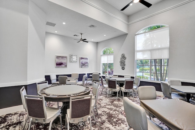 dining area featuring a towering ceiling, a wealth of natural light, and ceiling fan