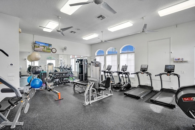 exercise room featuring ceiling fan and a textured ceiling