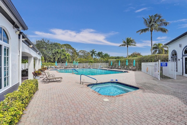 view of pool with a hot tub and a patio