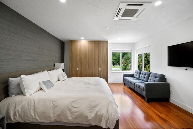 bedroom featuring hardwood / wood-style floors and a textured ceiling