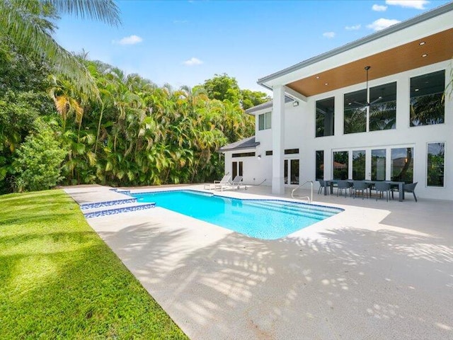 view of swimming pool with a patio and a yard