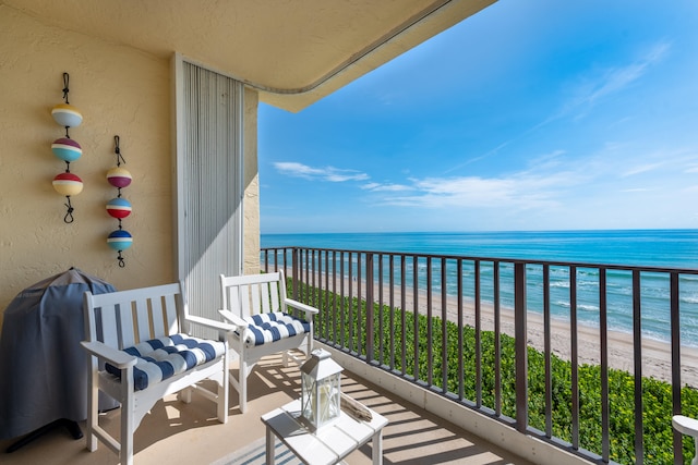 balcony featuring a beach view and a water view