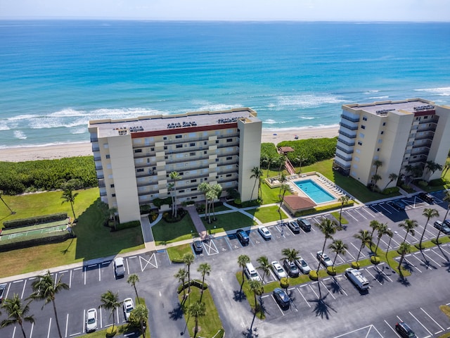 birds eye view of property with a water view and a beach view