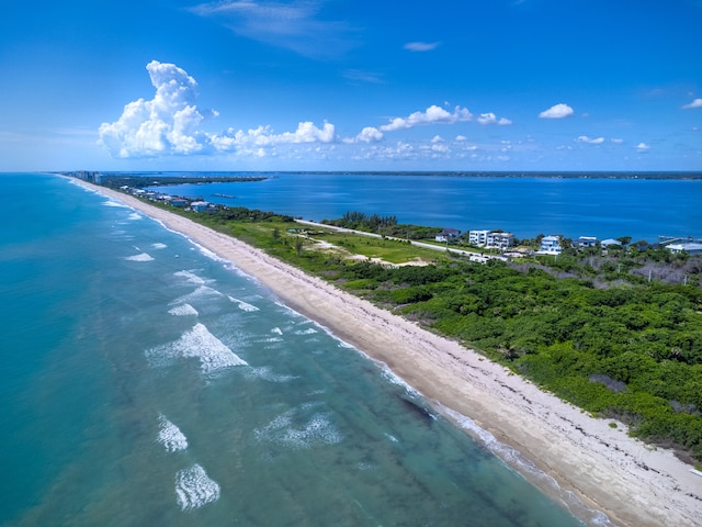 bird's eye view featuring a water view and a beach view