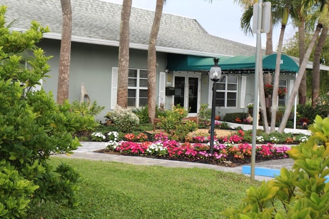 rear view of property featuring a lawn