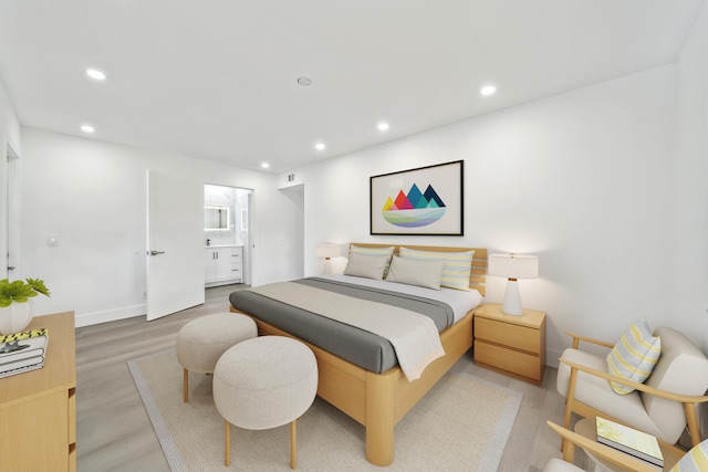 bedroom with ensuite bath and wood-type flooring