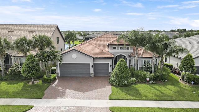 mediterranean / spanish home with a garage and a front lawn