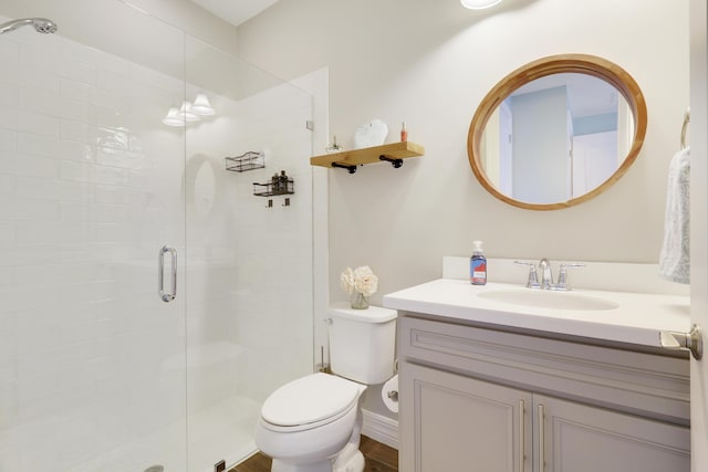 bathroom with vanity, a shower with shower door, and toilet