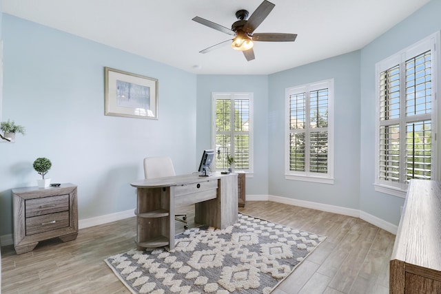 home office with light hardwood / wood-style flooring and ceiling fan