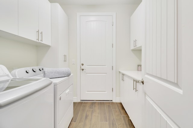 clothes washing area with cabinets and independent washer and dryer