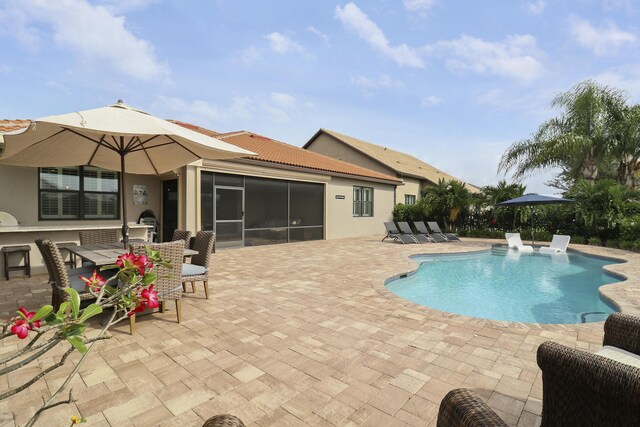 view of pool featuring a sunroom and a patio area