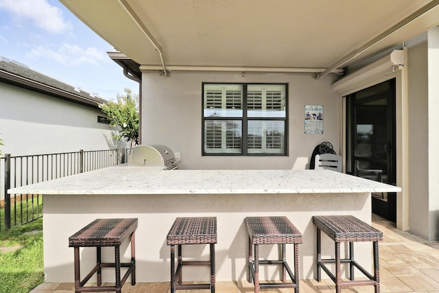 view of patio with an outdoor kitchen, an outdoor bar, and area for grilling