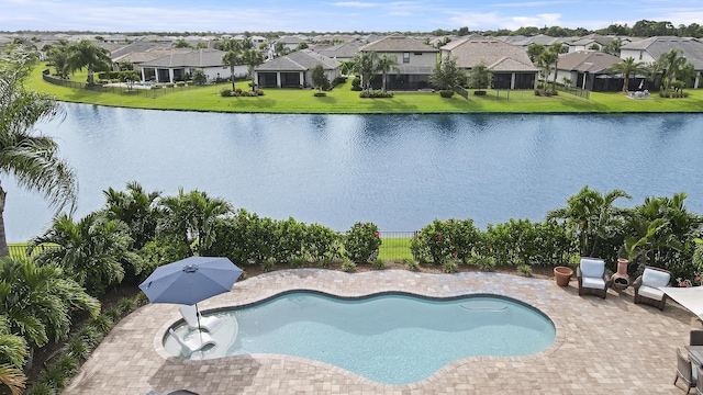 view of pool featuring a water view, a patio area, and a lawn