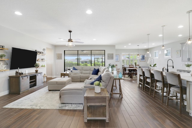 living room featuring dark wood-type flooring and ceiling fan