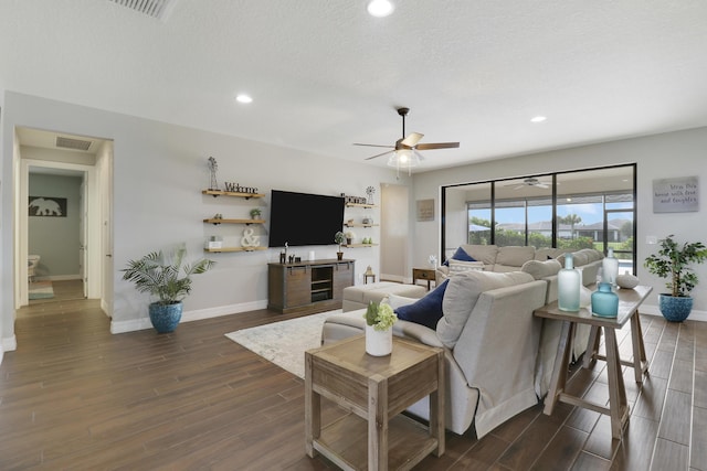 living room featuring ceiling fan, bar, a textured ceiling, and dark hardwood / wood-style flooring