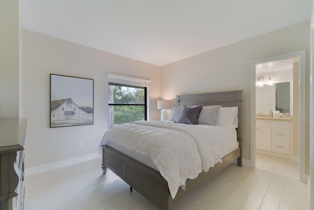 bedroom featuring connected bathroom and light wood-type flooring