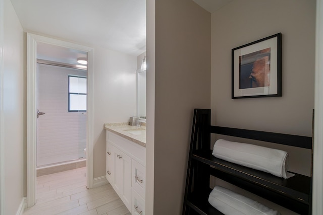 bathroom featuring a shower with door and vanity