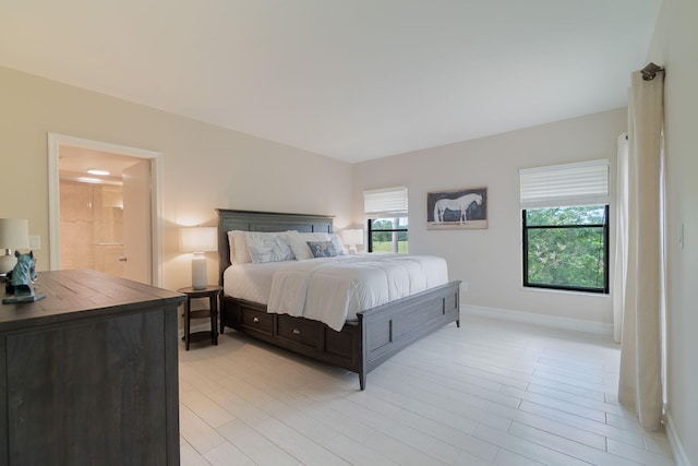 bedroom featuring light hardwood / wood-style flooring and ensuite bathroom