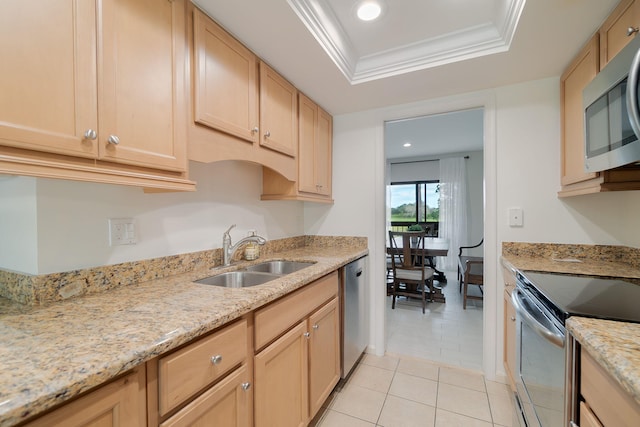 kitchen featuring light brown cabinetry, stainless steel appliances, a tray ceiling, sink, and light tile patterned floors