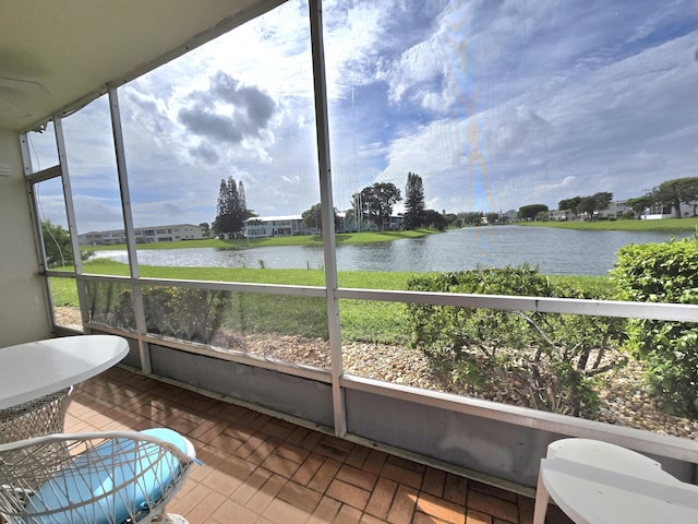 sunroom / solarium featuring a water view