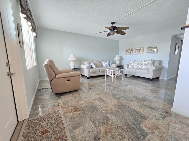 living room featuring a textured ceiling and ceiling fan