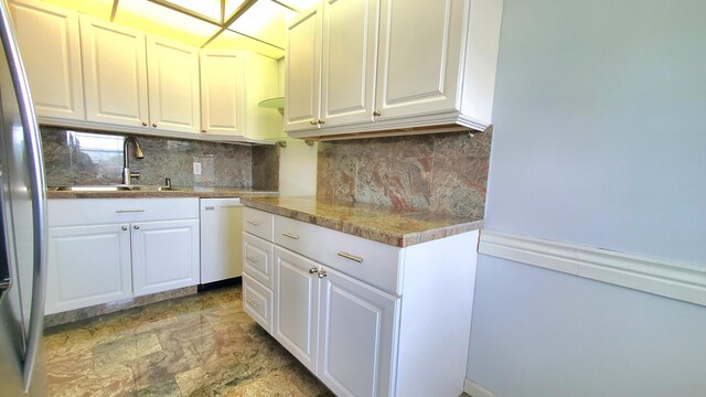 kitchen with stainless steel fridge, sink, white cabinets, and white dishwasher