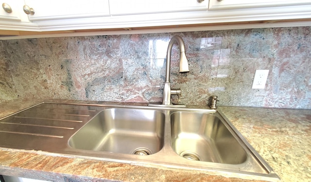 interior details with white cabinetry and sink