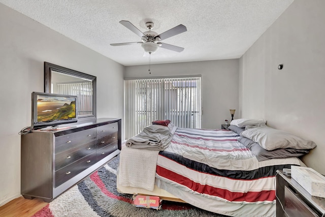 bedroom with light hardwood / wood-style floors, a textured ceiling, and ceiling fan