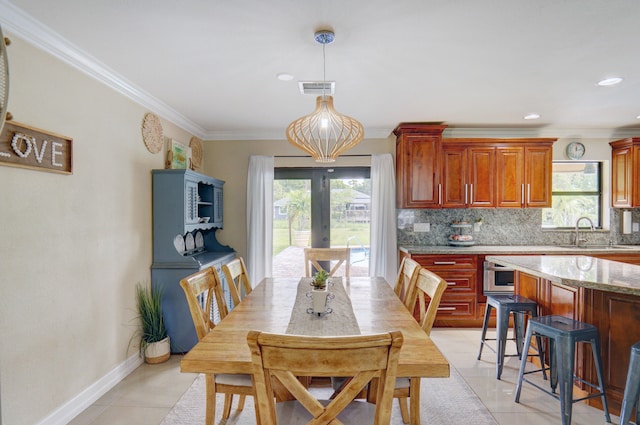 tiled dining room with a wealth of natural light, ornamental molding, and sink