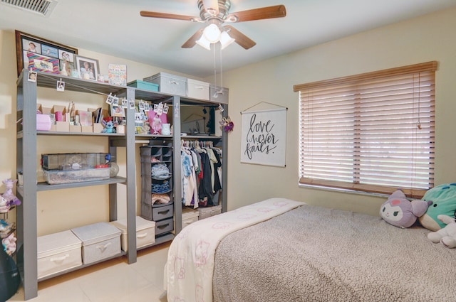 bedroom with ceiling fan, light tile patterned flooring, and a closet