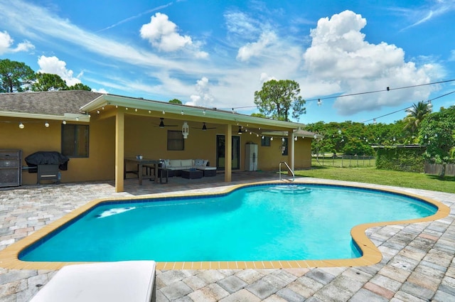 view of swimming pool with an outdoor living space, ceiling fan, and a patio area