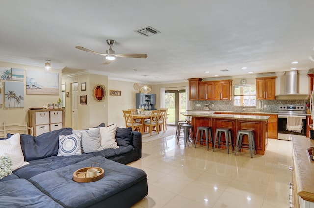 living room featuring light tile patterned floors, ceiling fan, crown molding, and sink