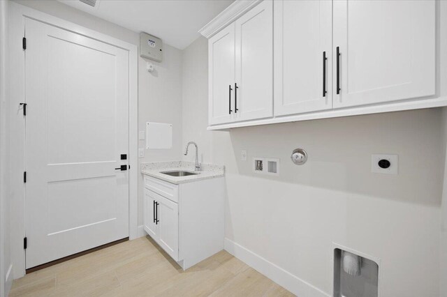 laundry room featuring gas dryer hookup, hookup for an electric dryer, sink, light hardwood / wood-style floors, and hookup for a washing machine