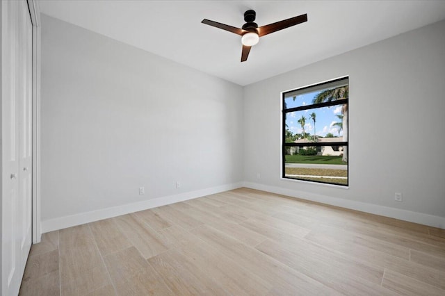 spare room with light wood-type flooring and ceiling fan