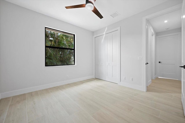 unfurnished bedroom with light hardwood / wood-style flooring, a closet, and ceiling fan