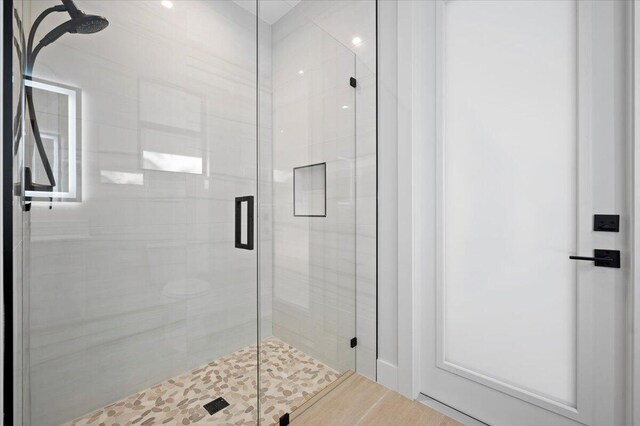 bathroom with a shower with door