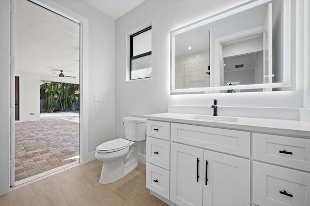 bathroom featuring vanity, toilet, and ceiling fan