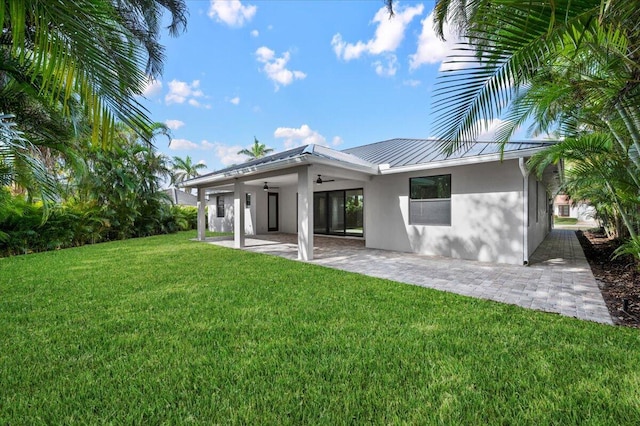 back of house featuring a patio area, ceiling fan, and a lawn