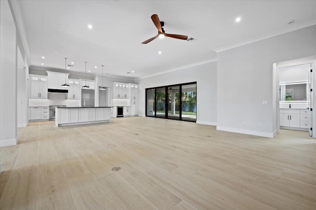 unfurnished living room with light hardwood / wood-style flooring, ornamental molding, and ceiling fan