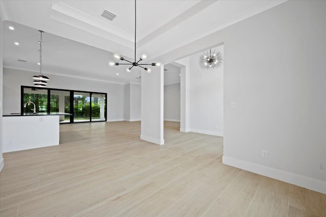 unfurnished living room with sink, light hardwood / wood-style floors, a tray ceiling, a notable chandelier, and ornamental molding