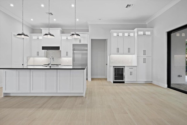 kitchen with pendant lighting, stainless steel built in refrigerator, sink, white cabinets, and wine cooler