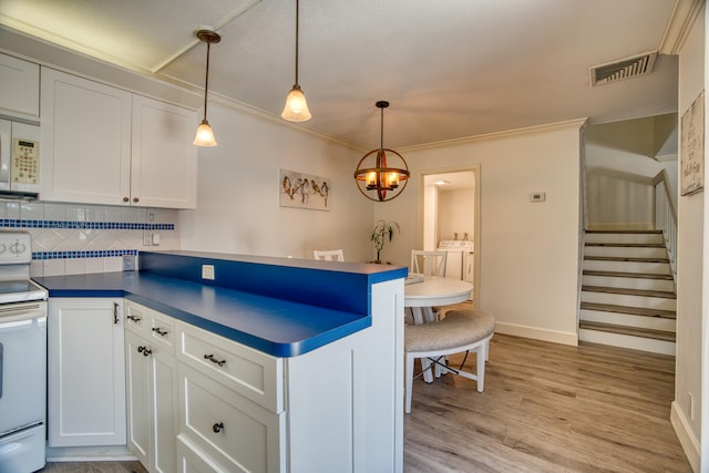 kitchen featuring decorative light fixtures, light hardwood / wood-style flooring, decorative backsplash, and white appliances