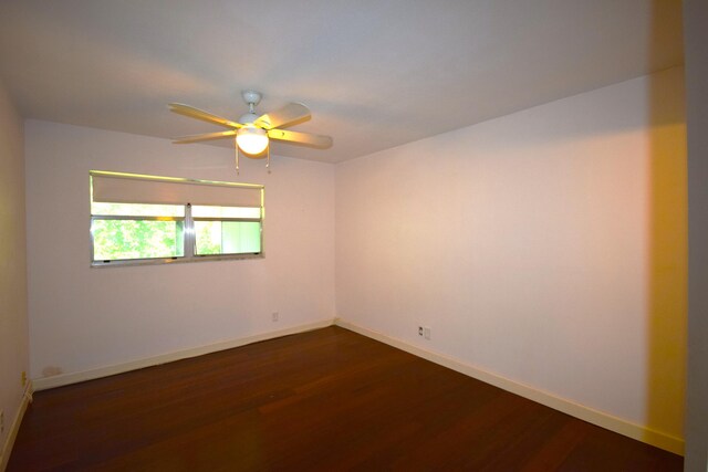 empty room with dark wood-type flooring and ceiling fan