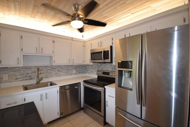 kitchen with sink, white cabinetry, tasteful backsplash, light tile patterned floors, and appliances with stainless steel finishes